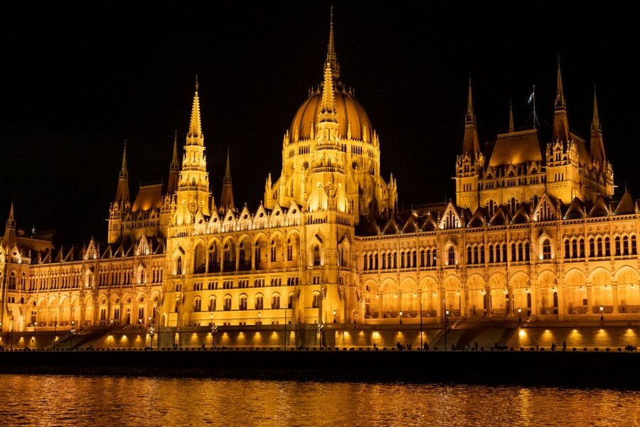 The Hungarian Parliament lit gold above the Danube at night